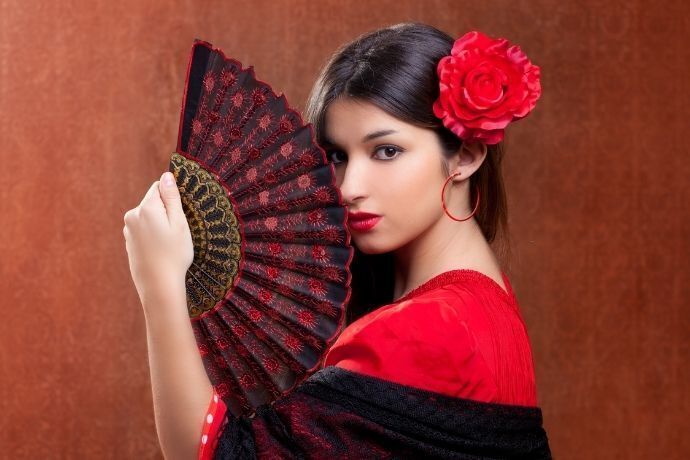 Mulher cigana com roupa vermelha e preta segurando um leque