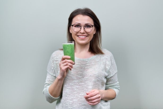 Mulher tomando suco verde
