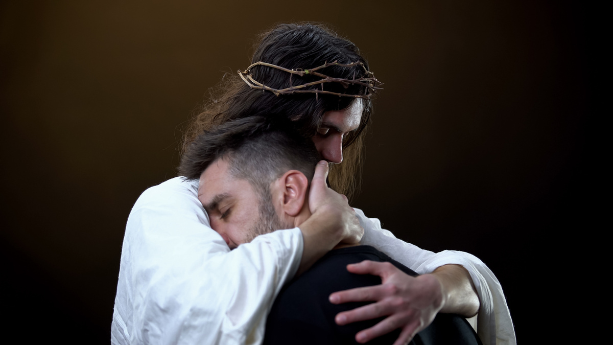 Homem sendo abraçado por Jesus.