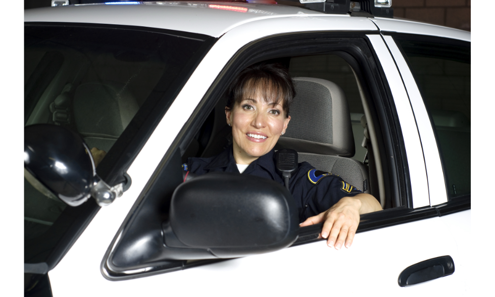 Mulher policial dentro de um carro.