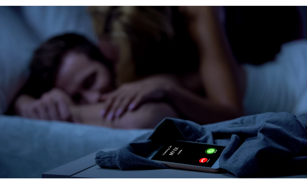 Ex-namorada ligando no celular e casal ao fundo na cama.