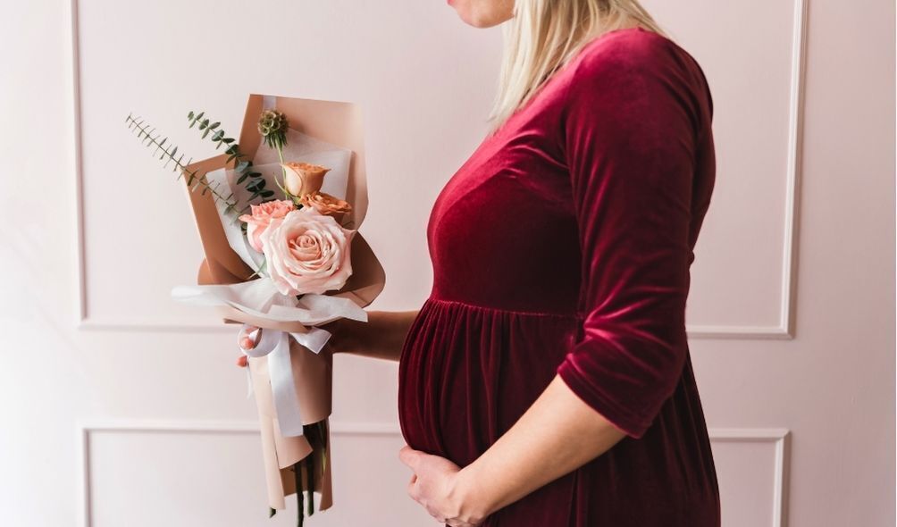 Mulher grávida com vestido de veludo vermelho