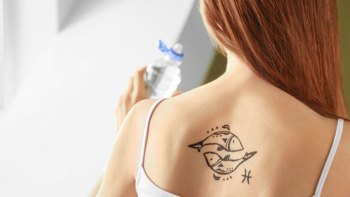 Mulher com tatuagem do signo de Peixes.