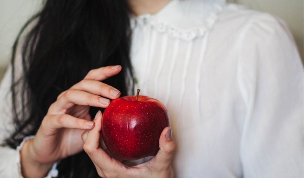 Mulher segurando maçã vermelha