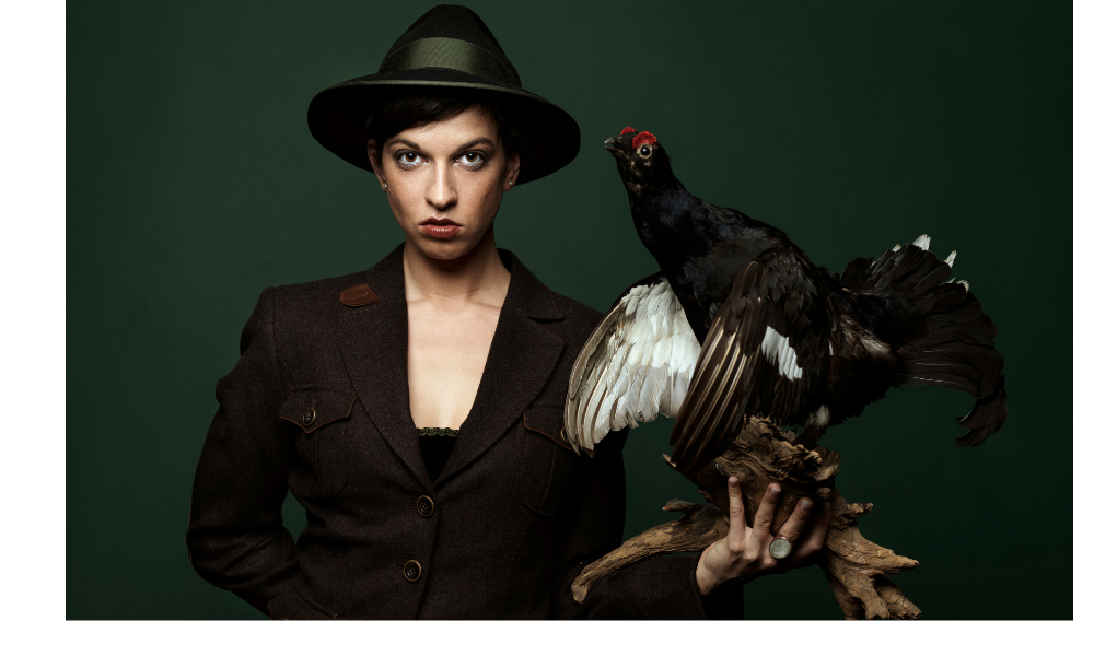 Mulher segurando uma galinha preta.