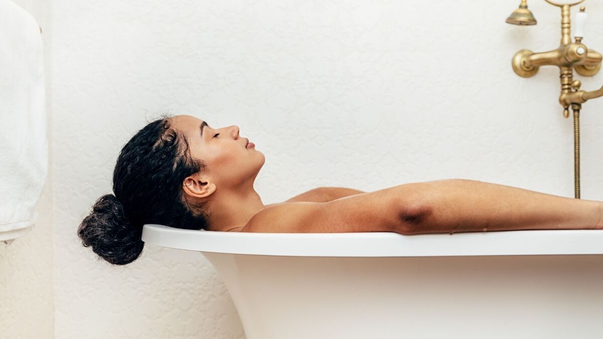 Mulher relaxando em uma banheira.
