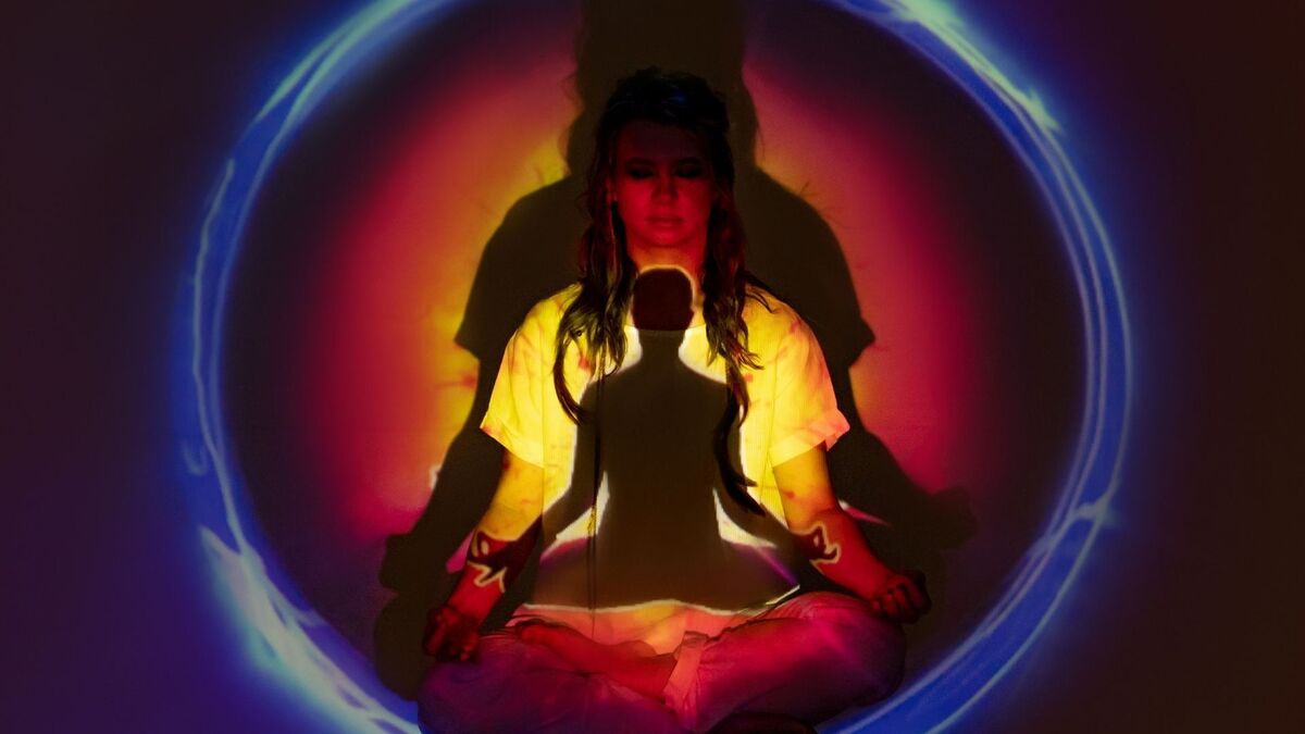 Imagem colorida de uma pessoa meditando.