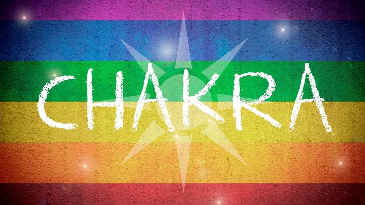 Palavra CHAKRA escrita na frente de uma bandeira com a cor do arco íris.