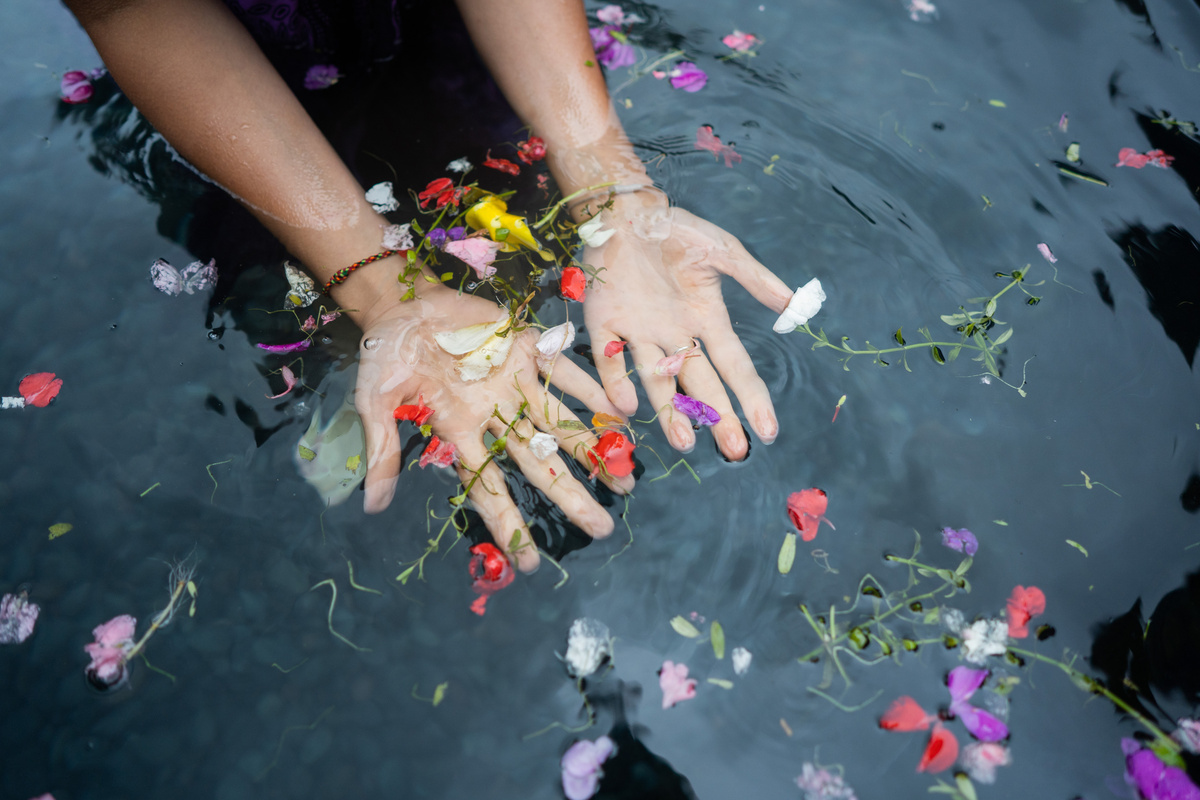 Mãos femininas em água com flores