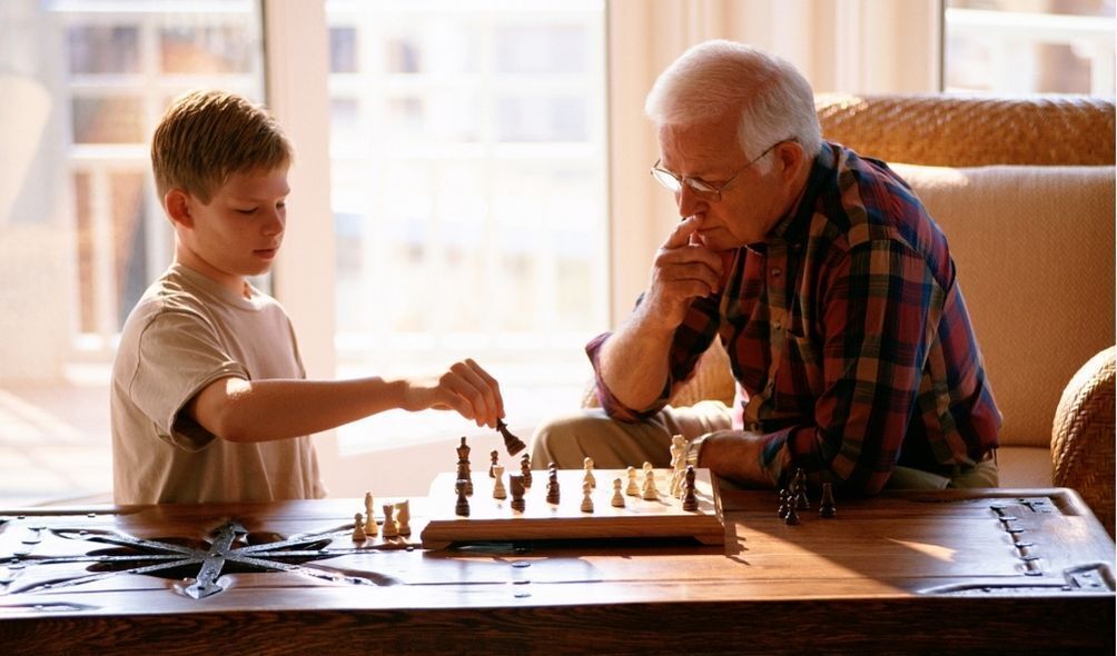 Avô e neto jogando xadrez