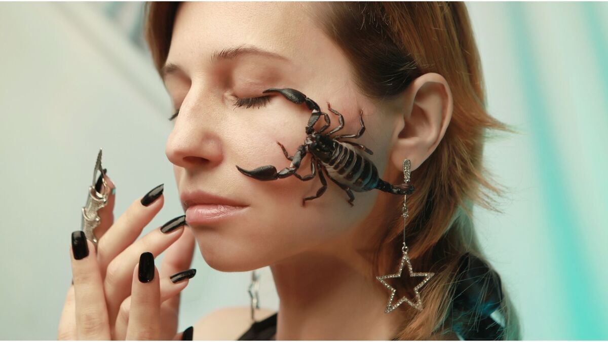 Mulher com escorpião no rosto.