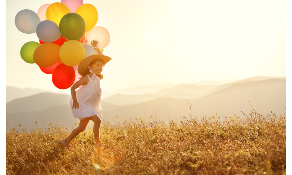 Criança correndo com balões.