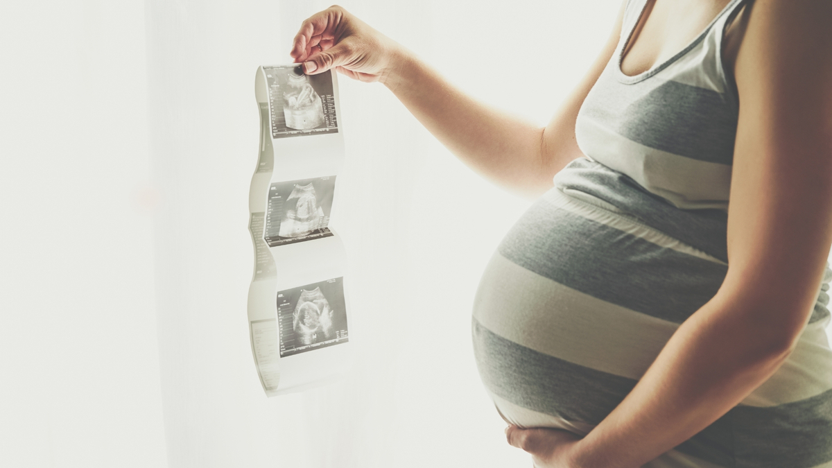 Mulher grávida olhando ultrassom.