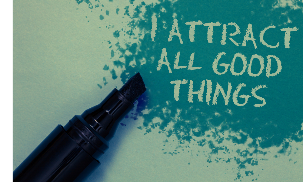 Escrito em uma folha "I attract all good things", ao lado de uma caneta.
