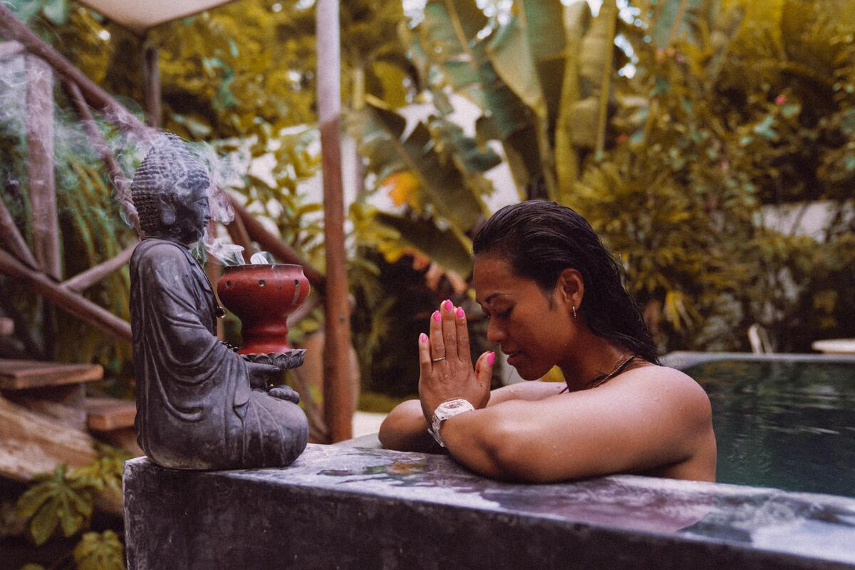 Mulher rezando para imagem de Buda. 