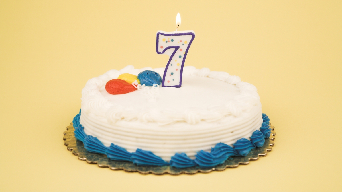 Número 7 em cima de um bolo de aniversário.
