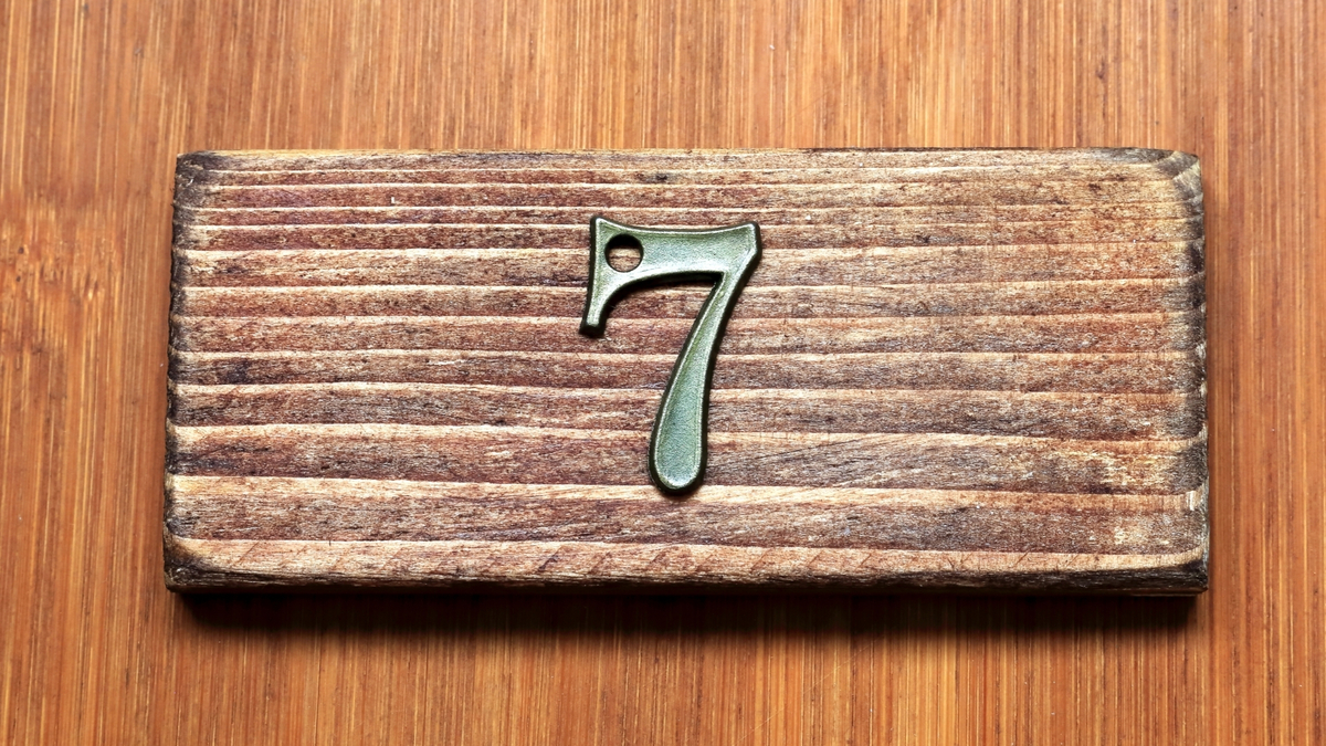 Número 7 em um fundo de madeira.