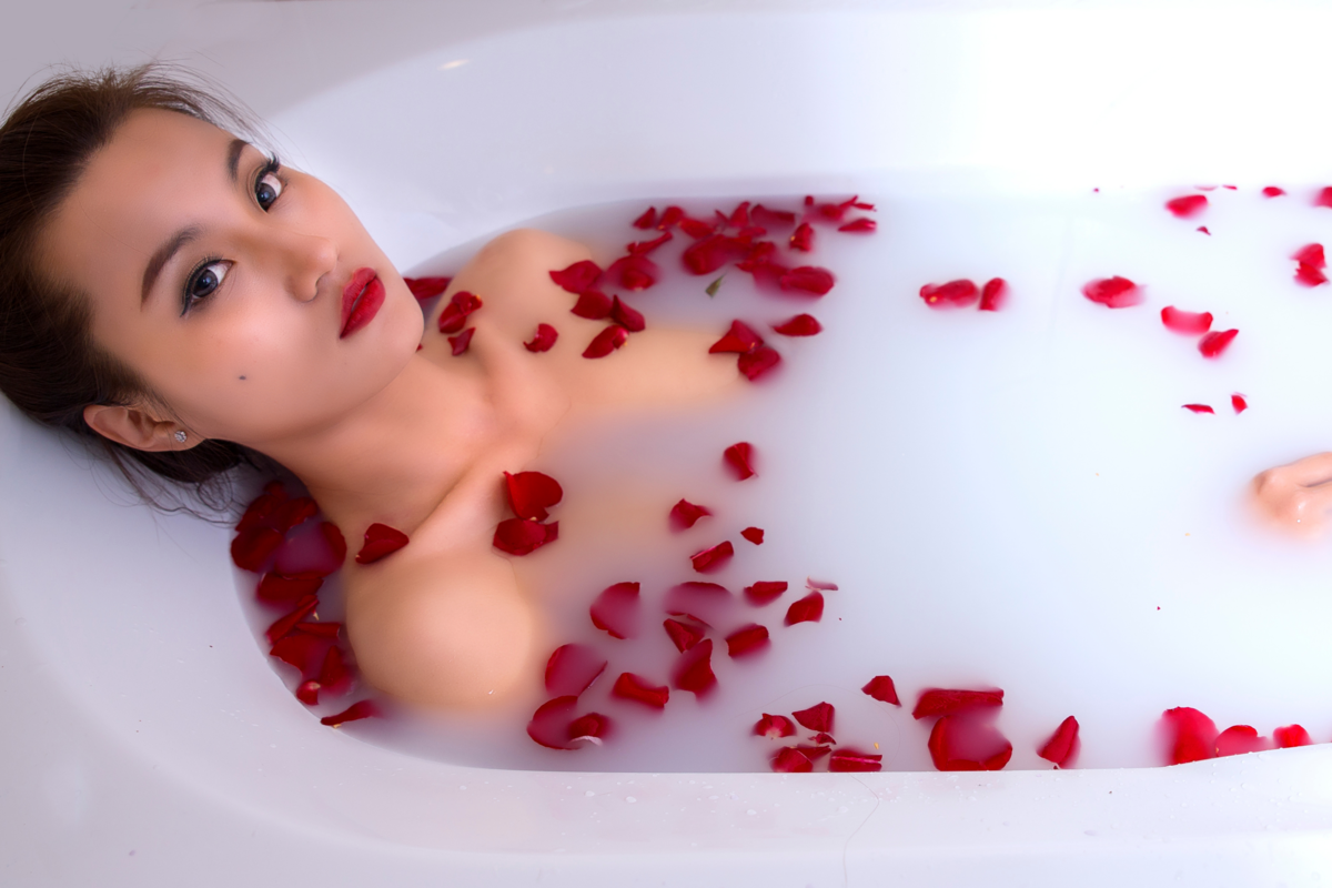 Mulher tomando banho de rosas.