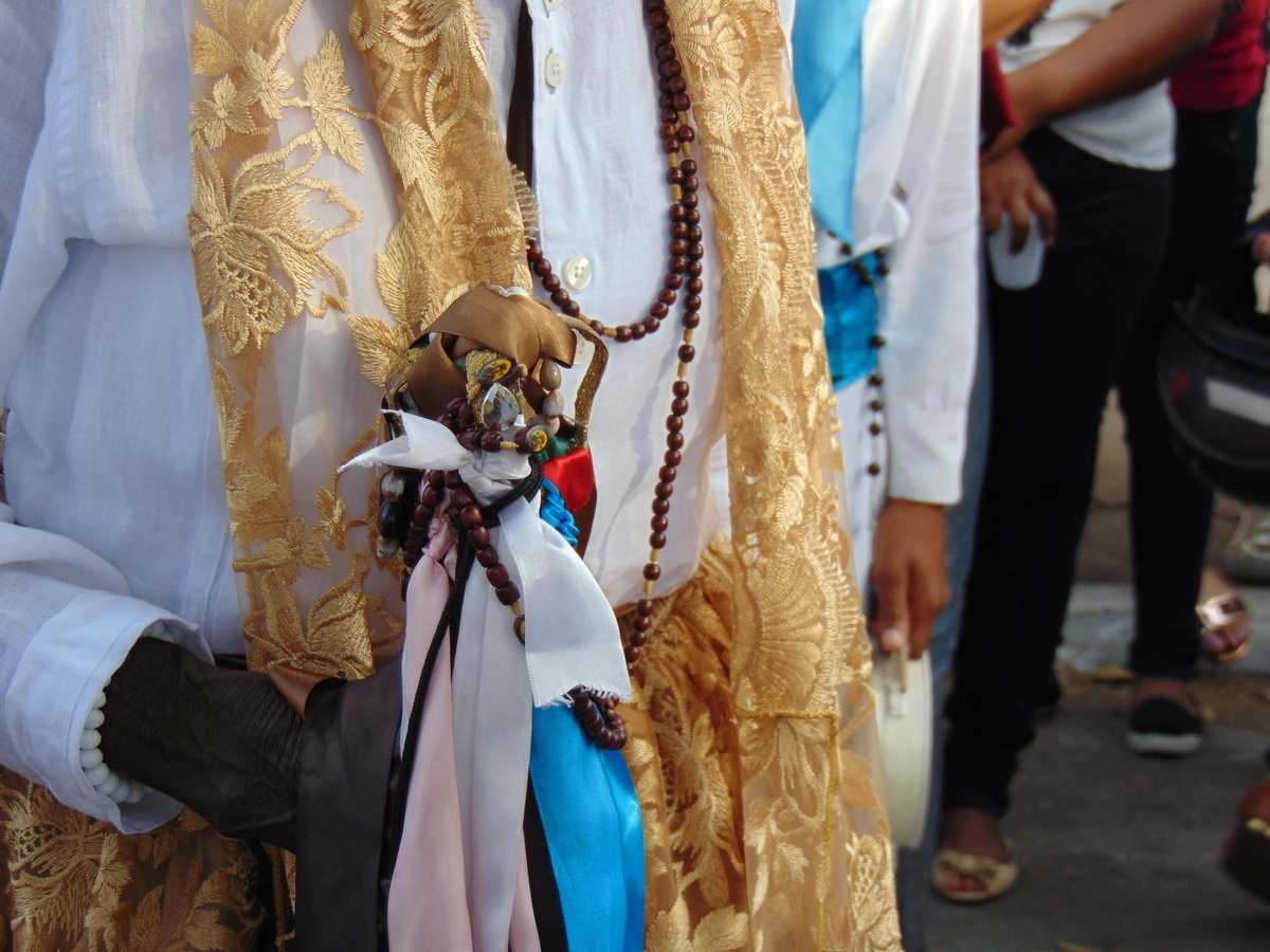 Pessoas trajadas de branco e usando cordões da Umbanda. 
