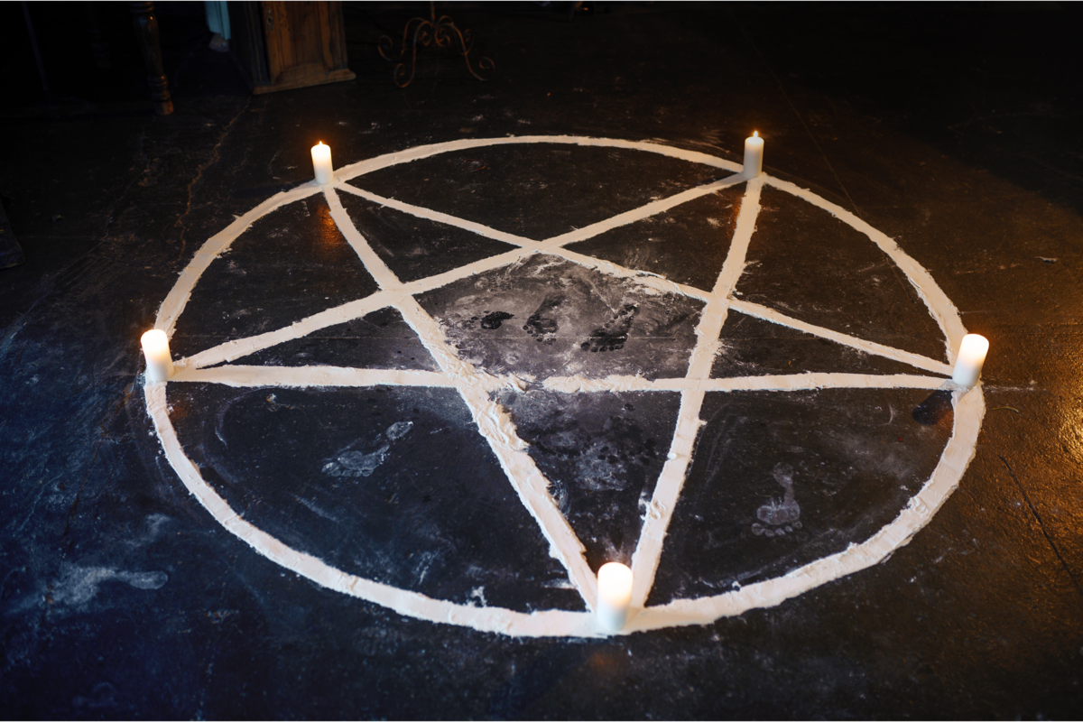 Pentagrama desenhado no chão com tinta branca.