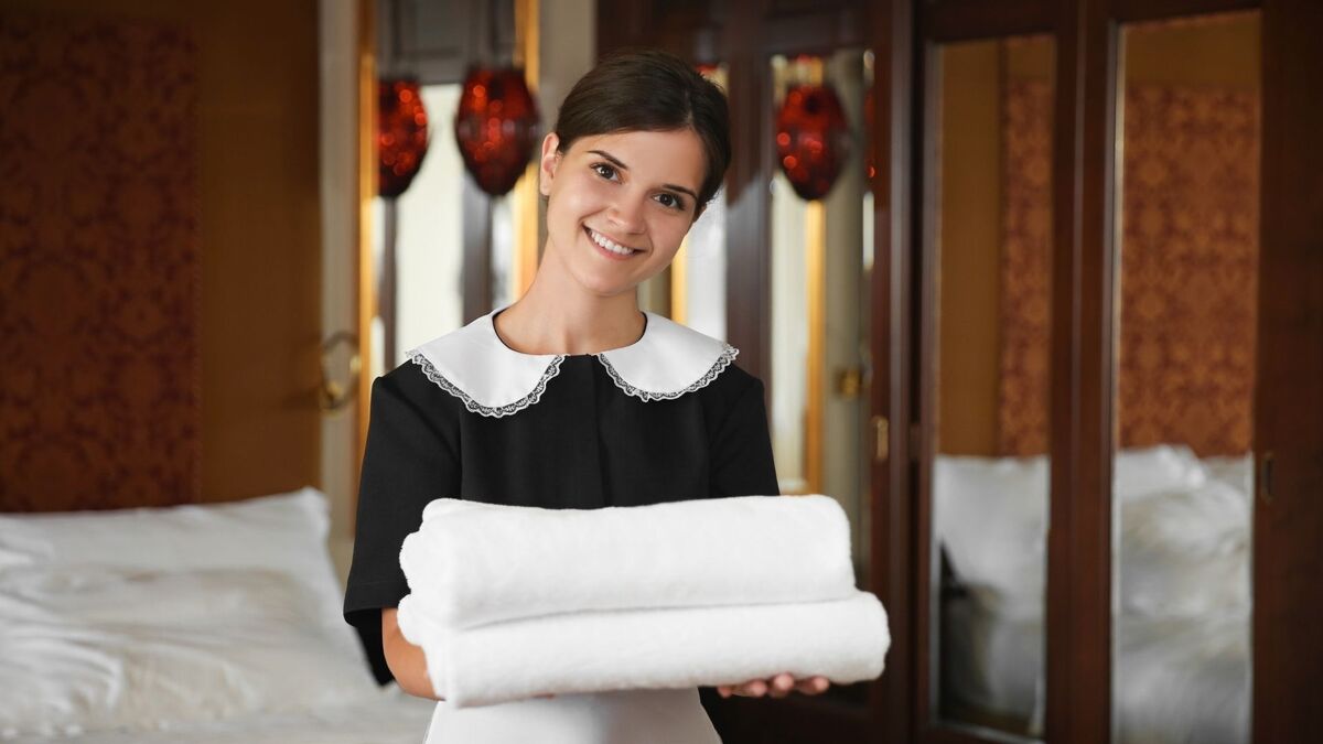 Empregada doméstica segurando toalhas.