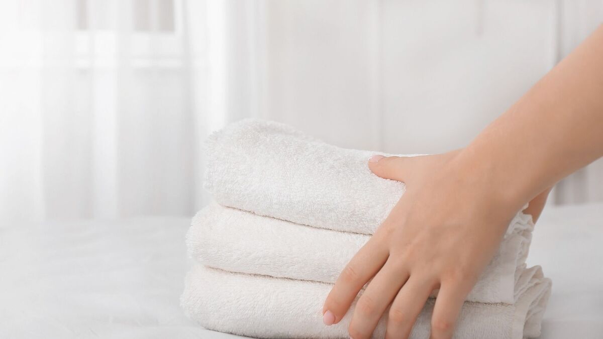 Uma mão levando duas toalhas.