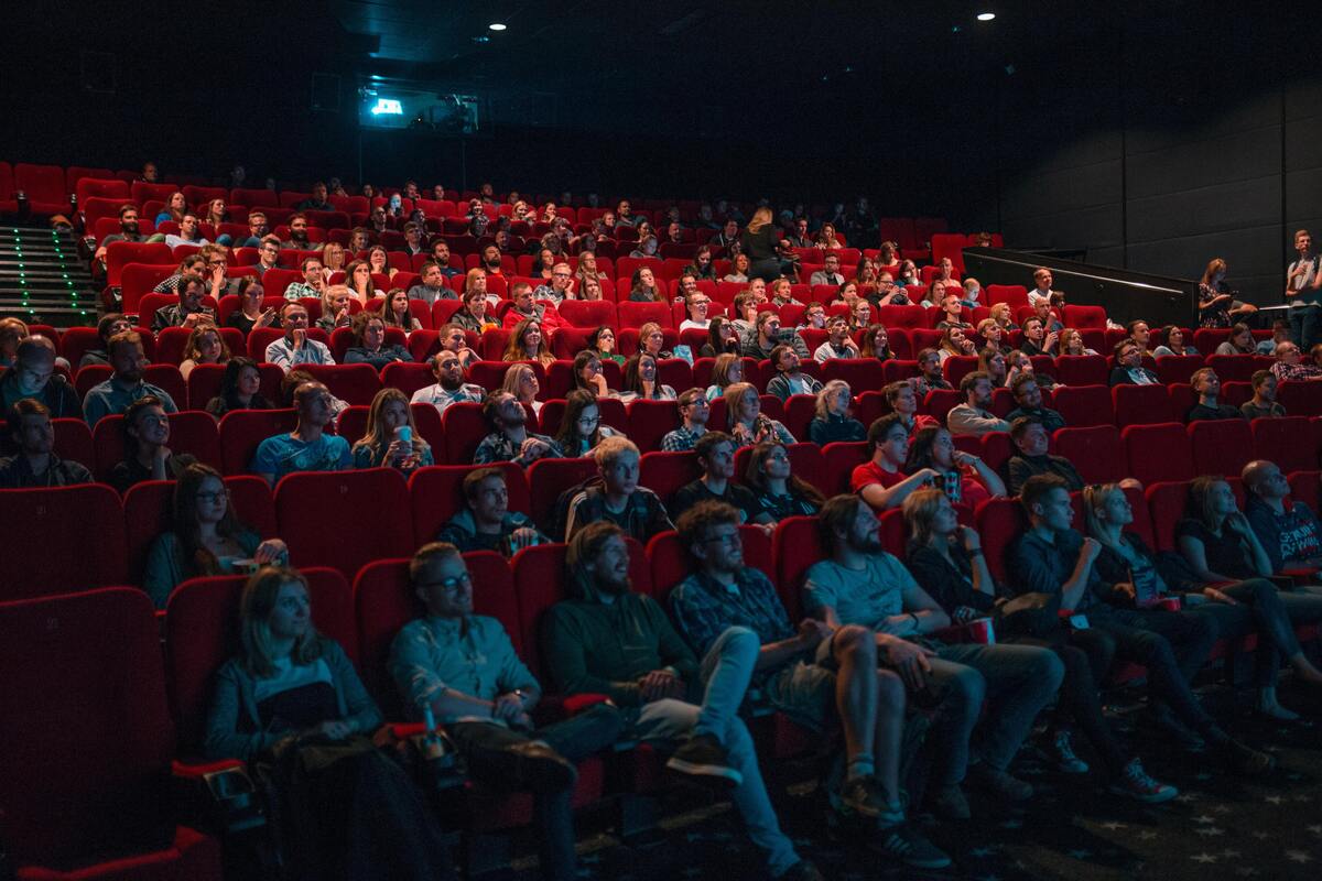 Pessoas assistindo a um filme em cinema grande