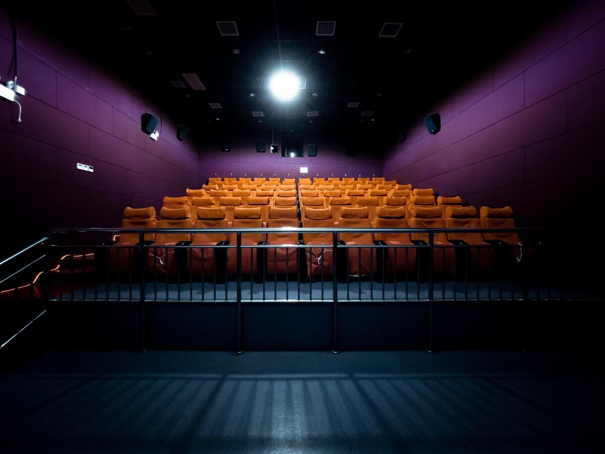 Cinema de paredes roxas e poltronas amarelas vazio