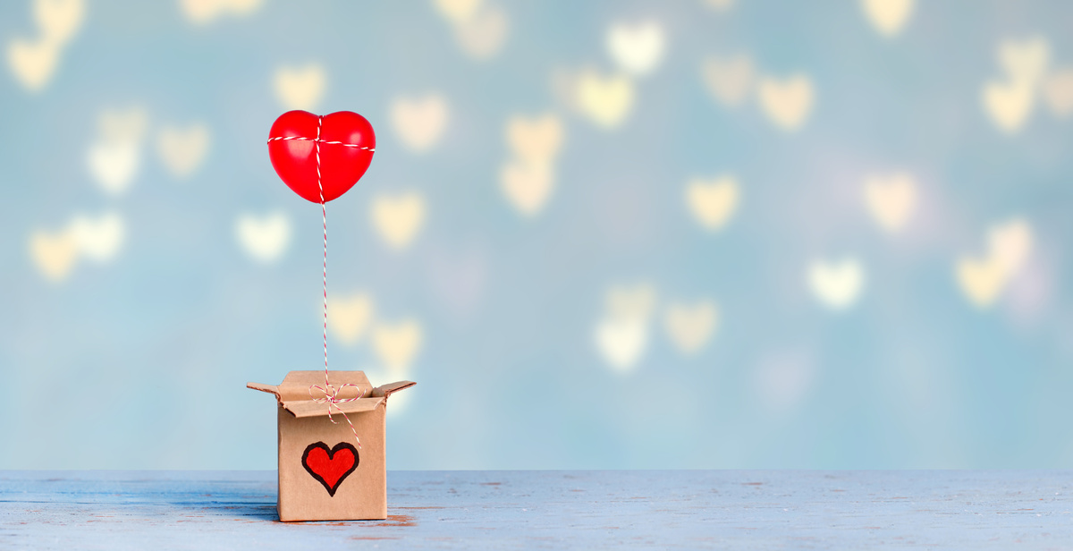 Balão de coração amarrado em uma caixa.