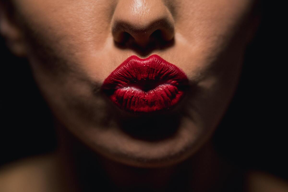 Mulher fazendo bico, usando batom vermelho.