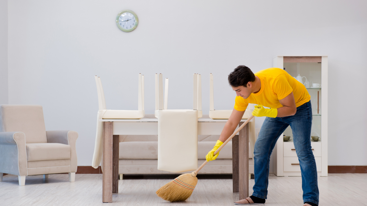 Um homem limpando a casa. 