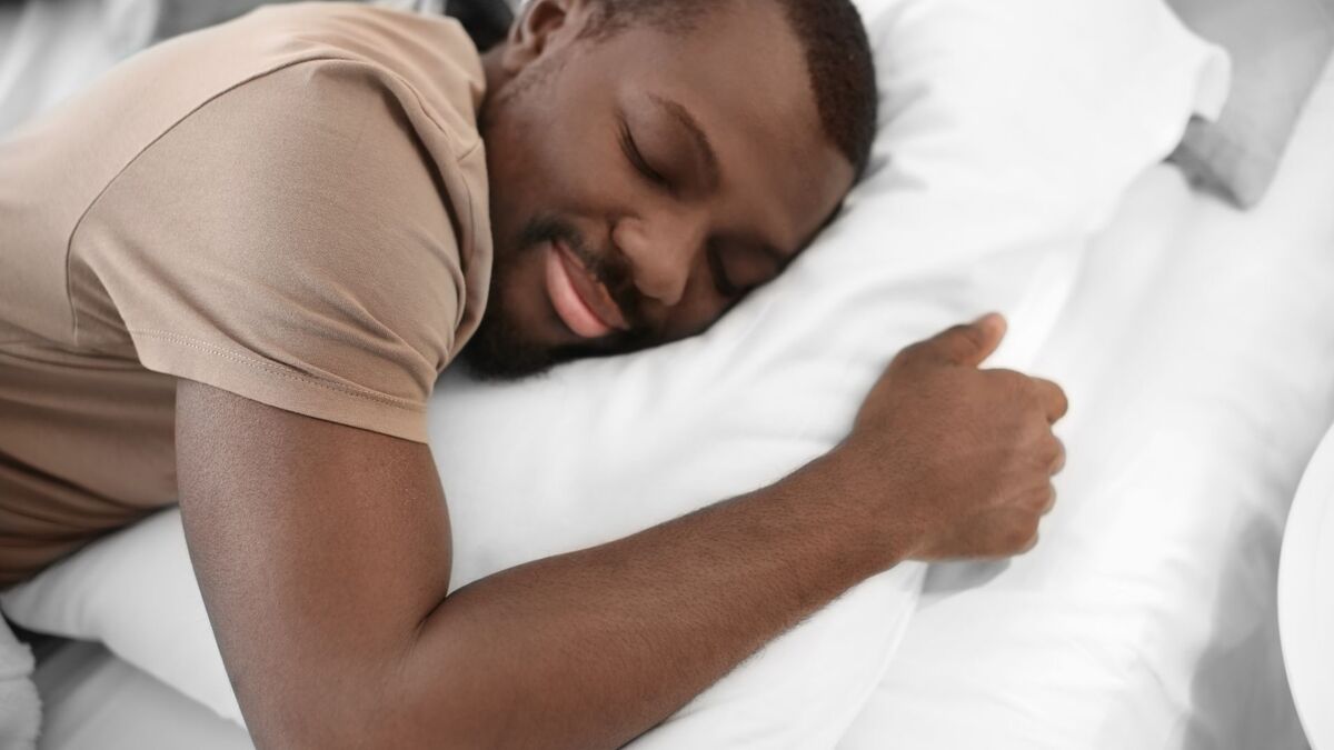 Homem dormindo com cara de feliz.