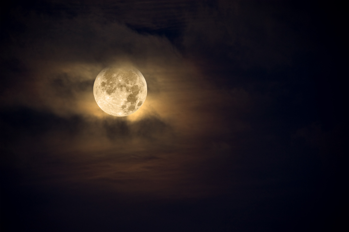 Lua cheia envolta de nuvens.