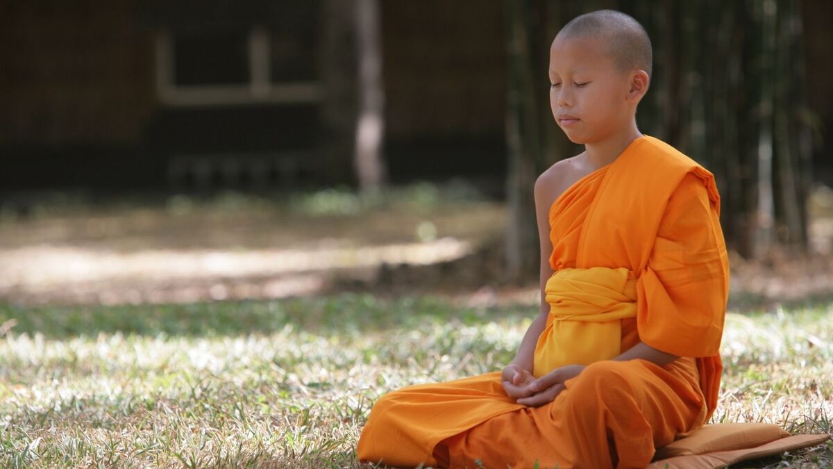 Criança budista meditando.