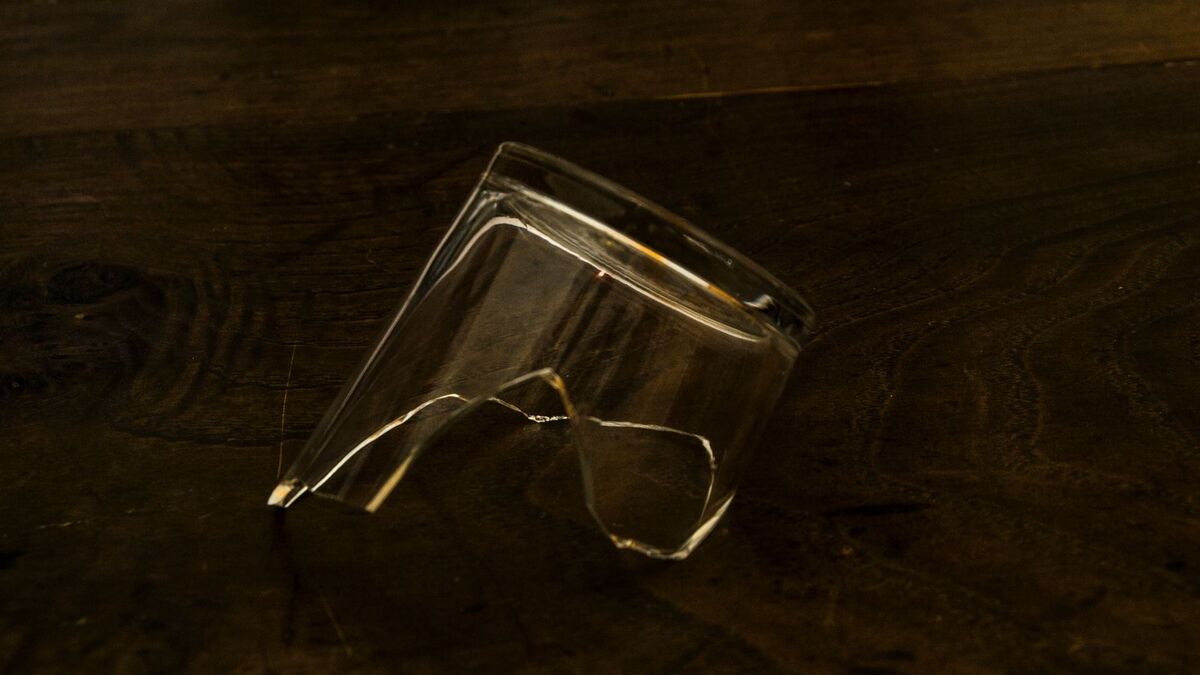 Copo de vidro quebrado na mesa.