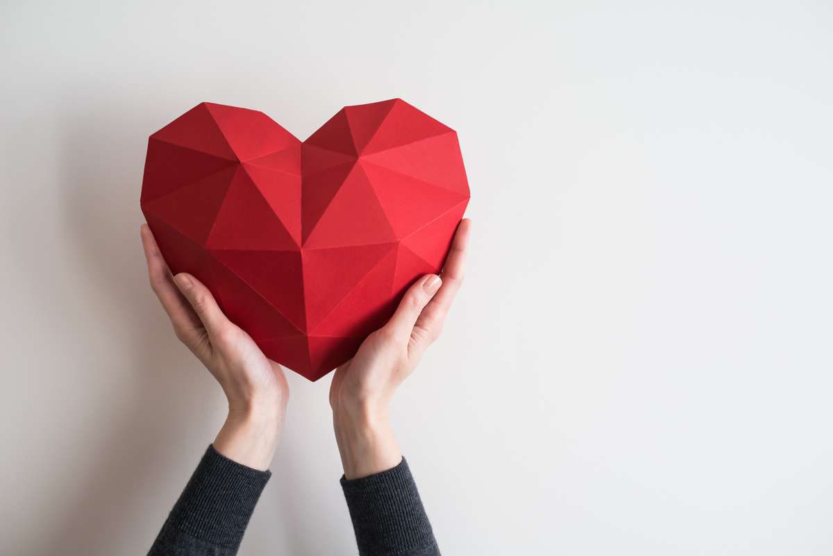 Pessoa segurando coração poligonal feito de papel