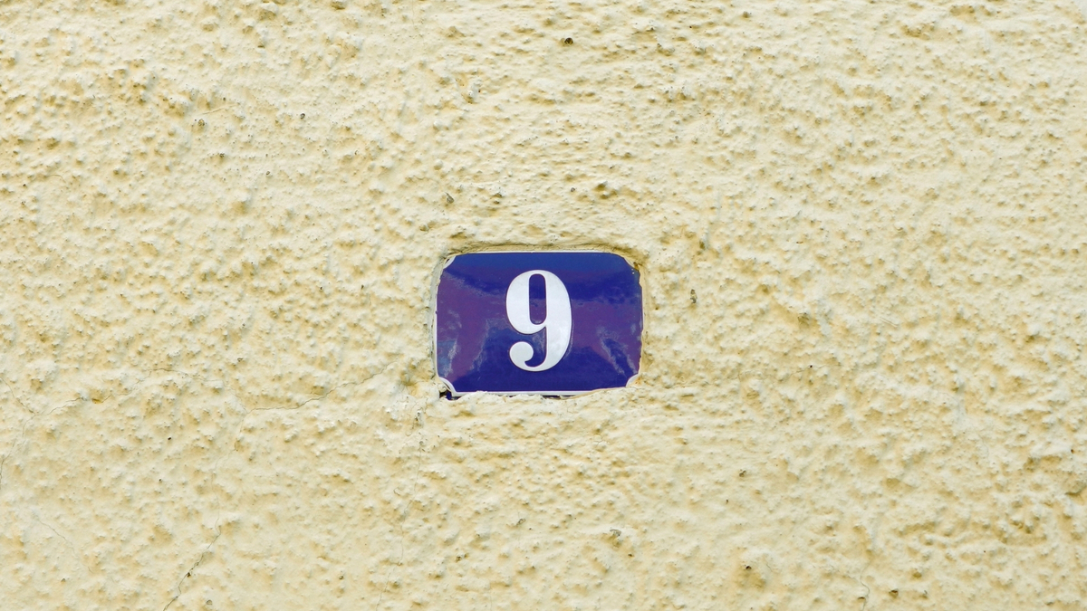 Número 9 no muro de uma casa.
