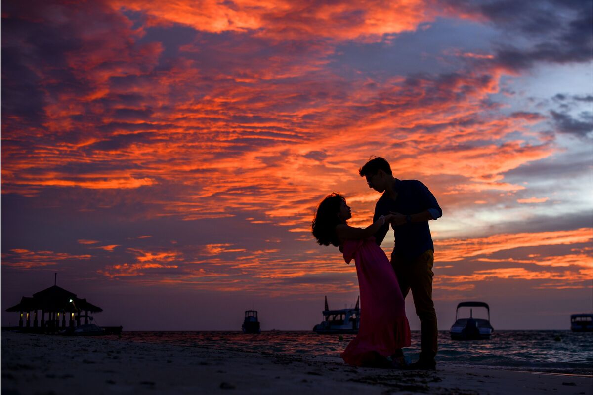 Casal dançando ao pôr do sol.