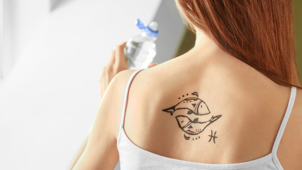 Tatuagem de peixes nas costas de uma mulher.