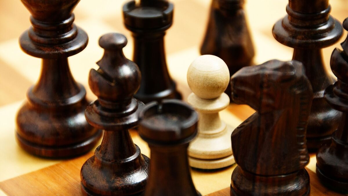 Peão de xadrez cercado por outras peças.