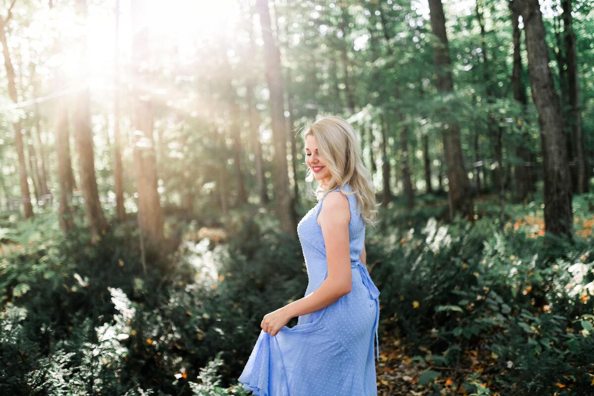 Mulher usando vestido azul em uma floresta.