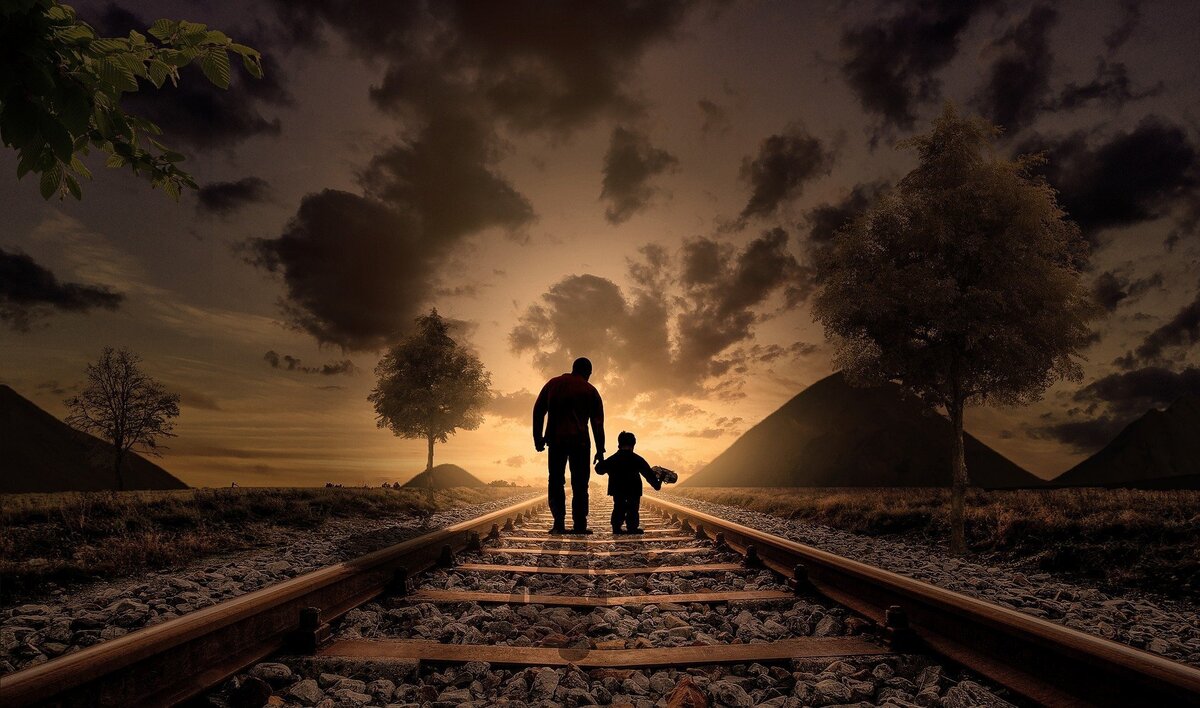 Homem e filho em linha de trem.