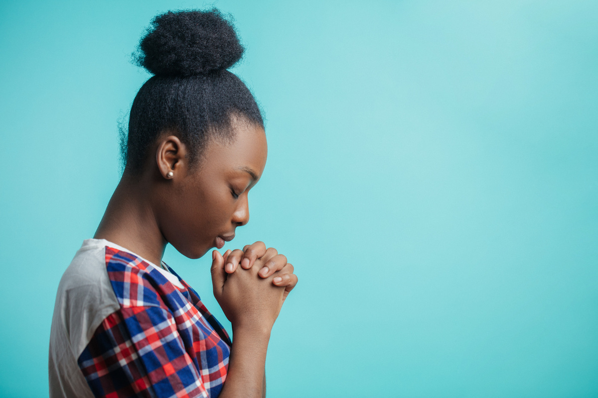 Mulher fazendo oração num fundo azul