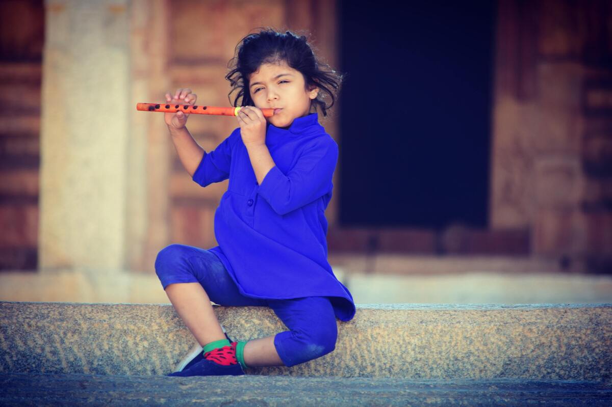 Criança tocando flauta.