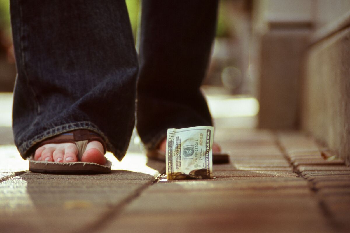 Pessoa achando dinheiro no chão.