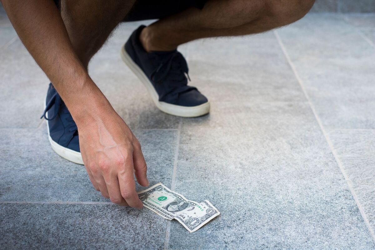 Homem achando dinheiro no chão.