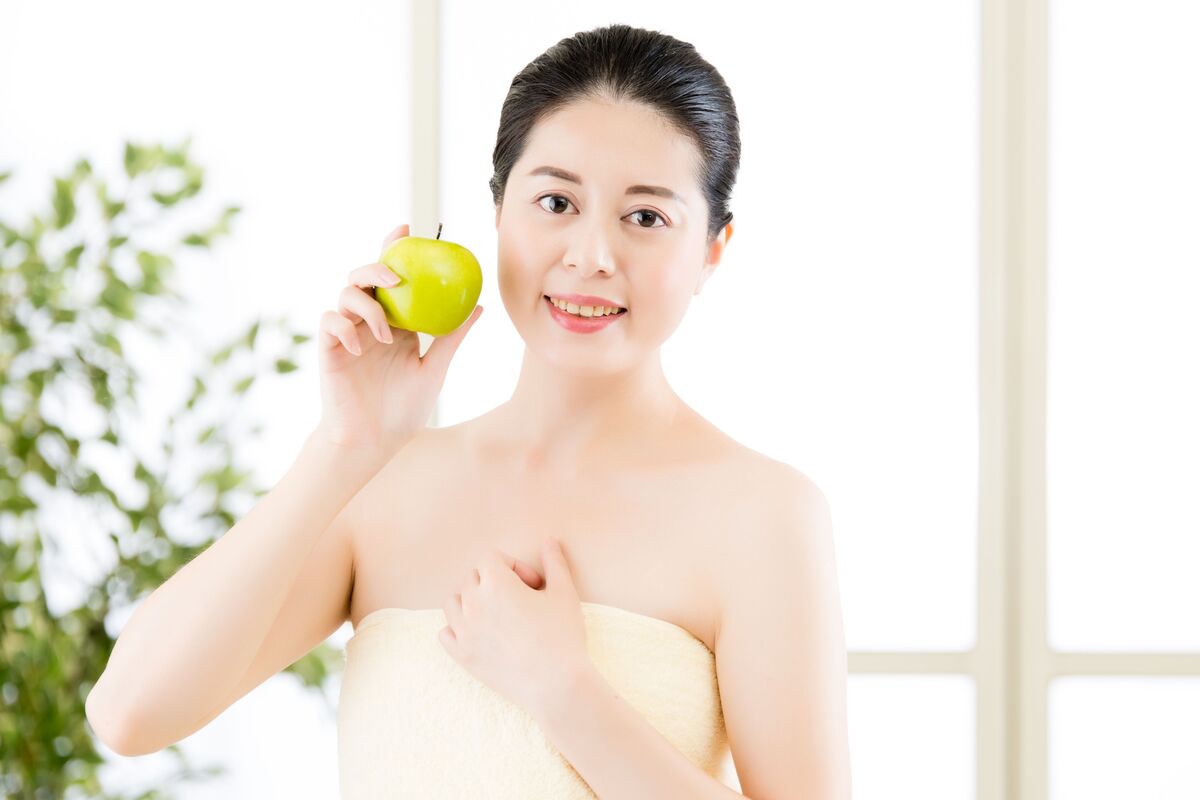 Mulher segurando maçã para banho.