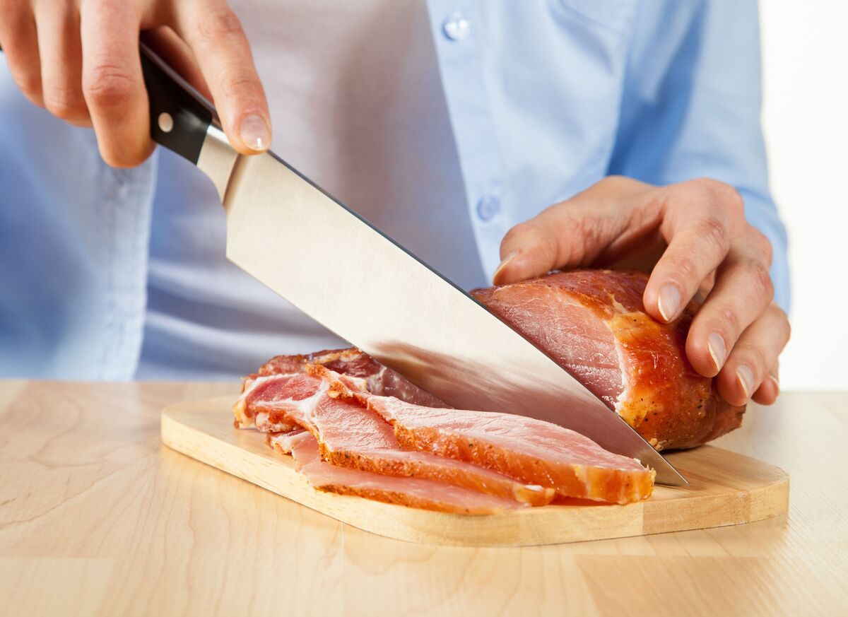 Pessoa cortando carne.