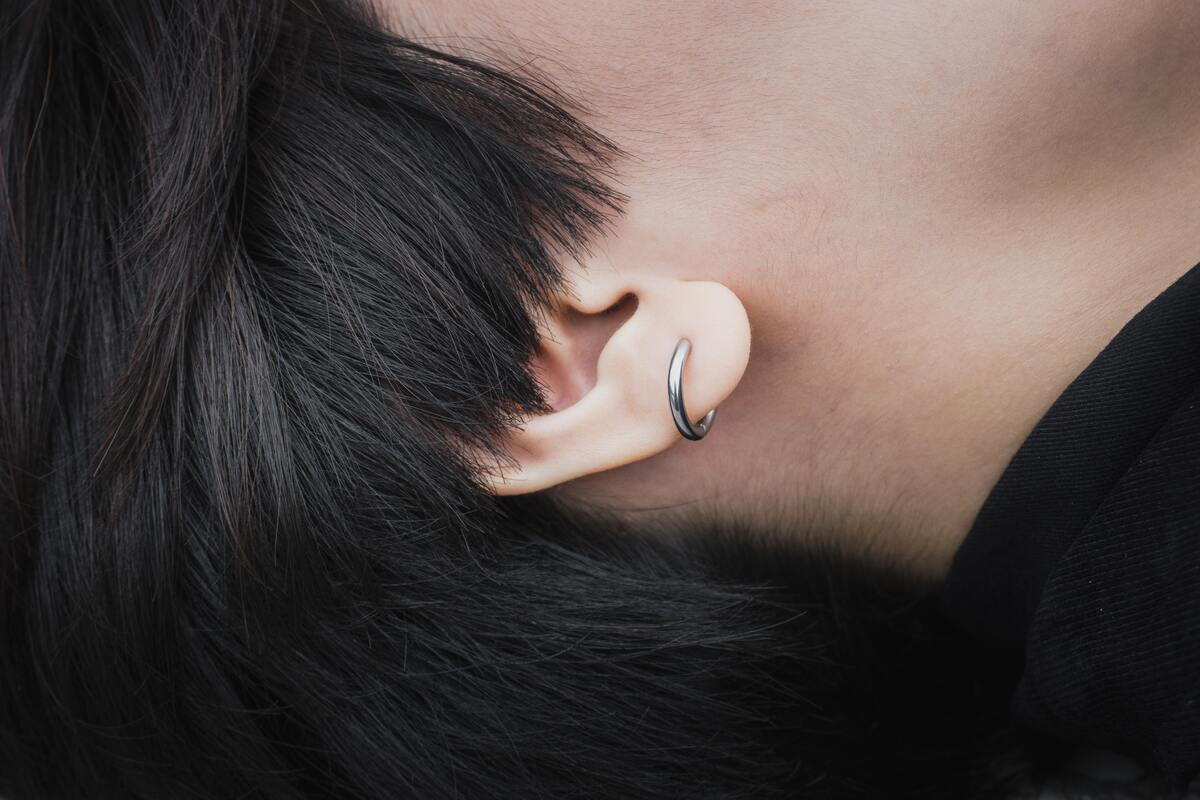 Homem com piercing na orelha.