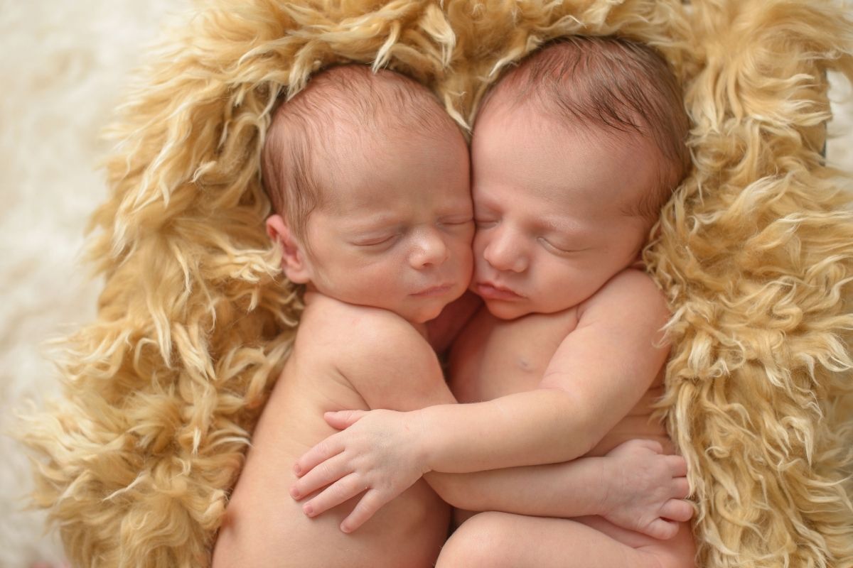 gêmeos recém-nascidos abraçados